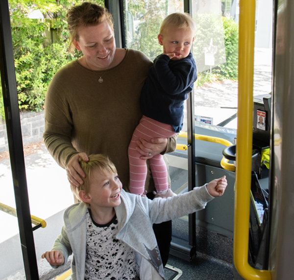mother with two young children boarding a bus